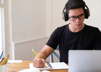 Young person studying at a clean desk with headphones on, showing how to train your brain to concentrate in a distraction-free environment